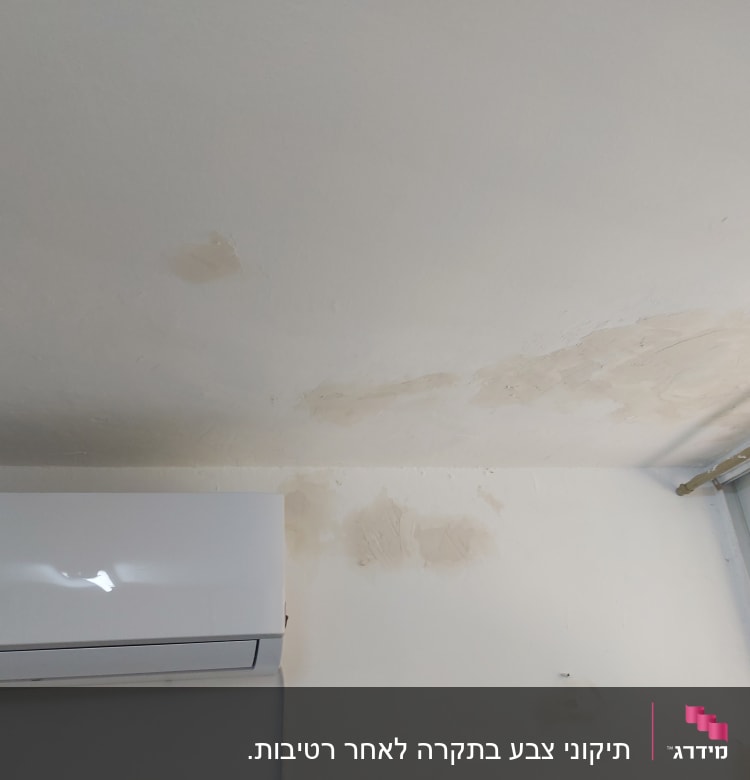 כתמי צבע על תקרה וקיר ליד חלון